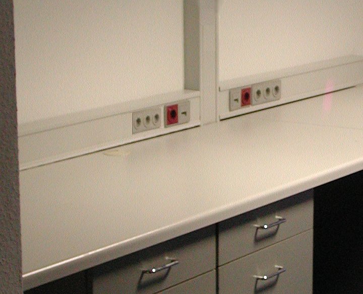 Arbeitsplätze mit farblich passendem lichtgrauen Brüstungskanal mit roten Steckdosen für Arbeitsstationen